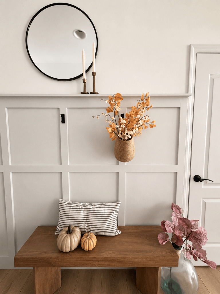 Neutral fall entryway decorated with pumpkins and autumn branches