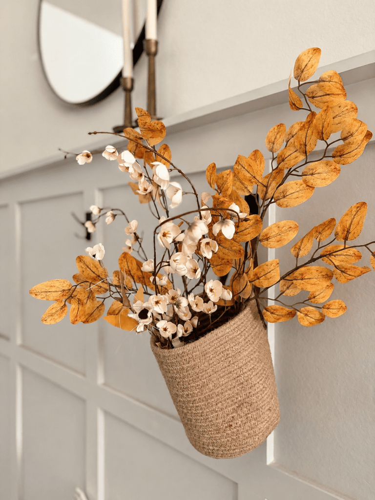 Hanging basket filled with neutral orange and cream fall branches