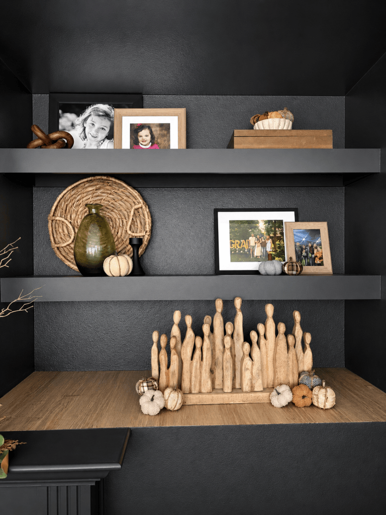 Black built-in shelves styled with family photos, neutral pumpkins and natural fall decor